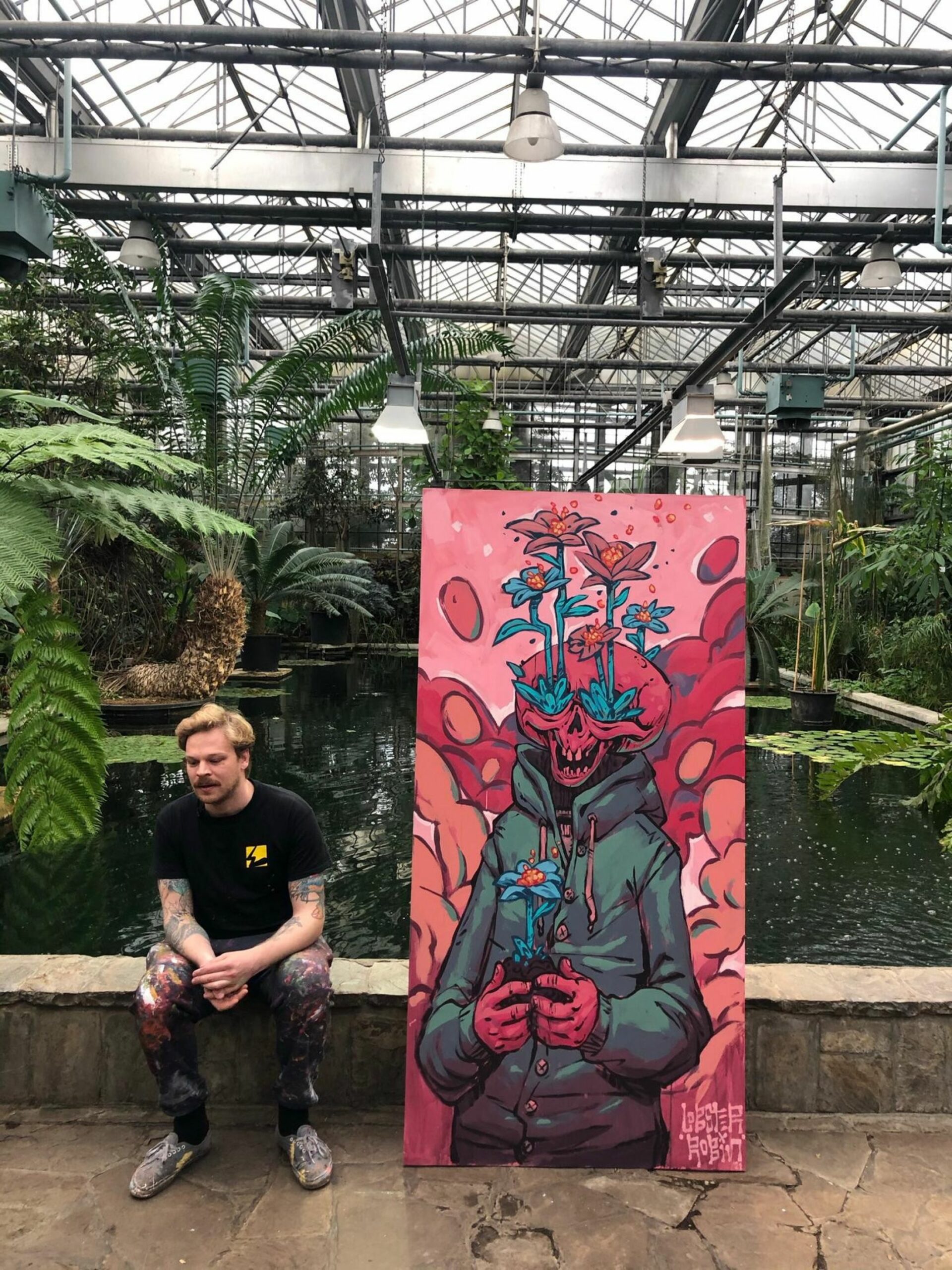 Kunstenaar met kunstwerk in plantentuin